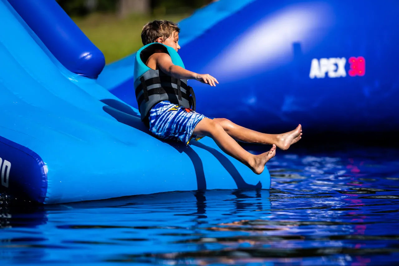 Kids playing on inflatable water park obstacles at Trophy Lakes Johns Island