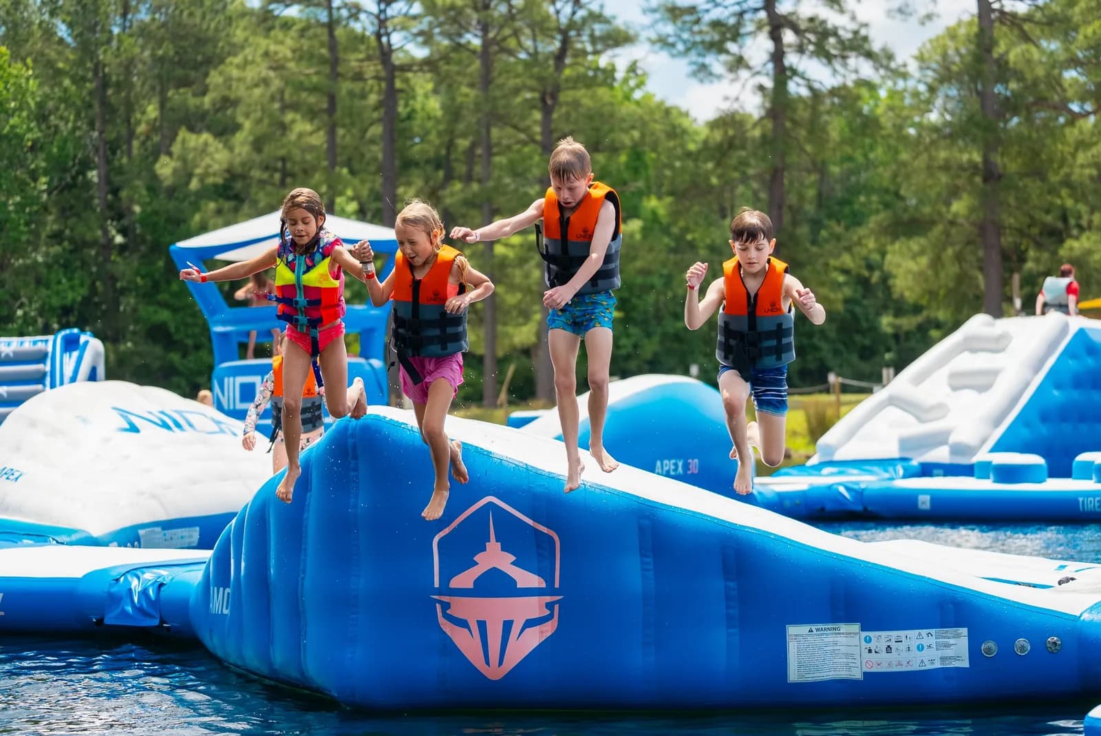 Kids in life jackets jumping off the inflatable Aqua Park at Charleston Aqua Park